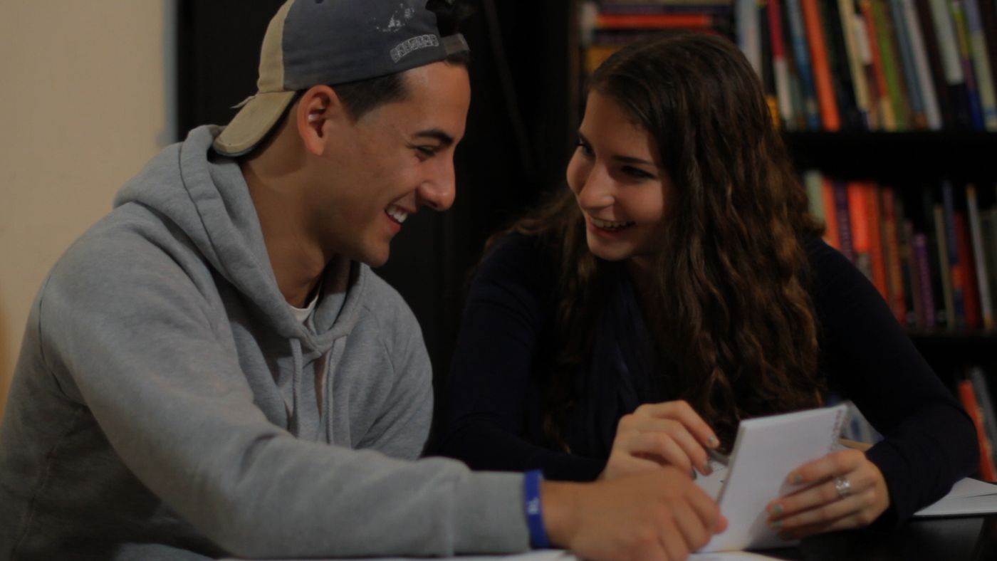Two teenagers laughing over a book, from Into the Twilight Haze